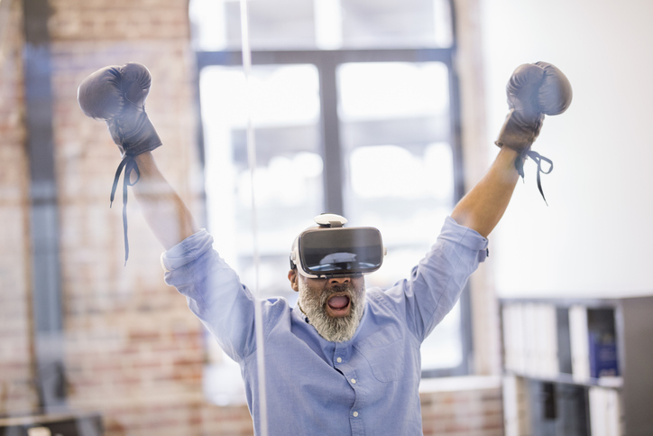 Portrait of businessman with Virtual Reality Glasses and boxing gloves in the office