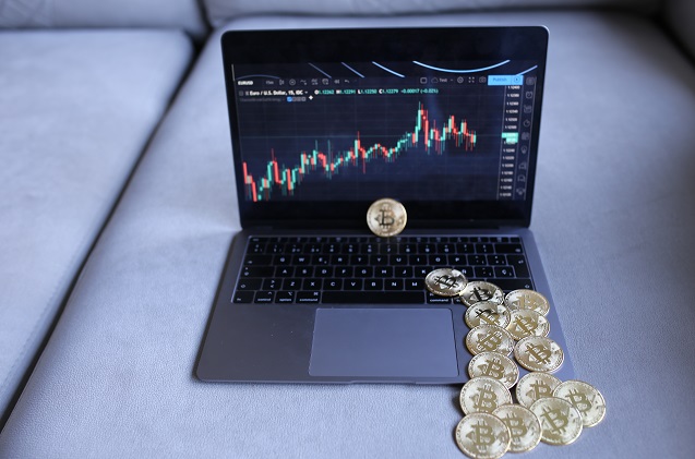 MONEDAS DE BITCOIN EN MESA LLENA DE TECNOLOGIA